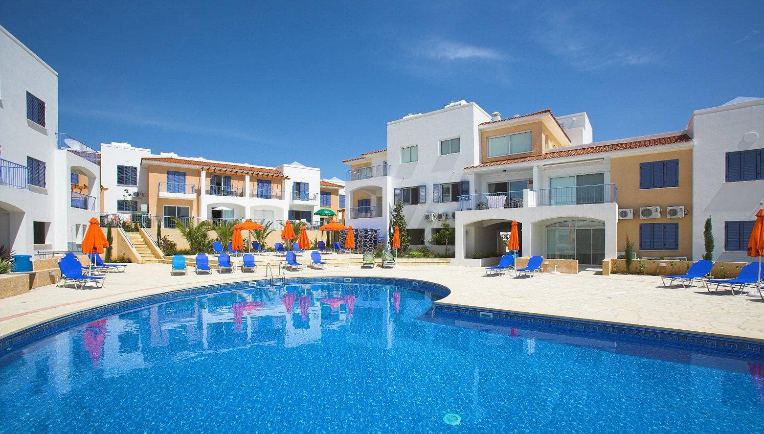 Complex of townhouses with a swimming pool and a green area close to sandy beaches